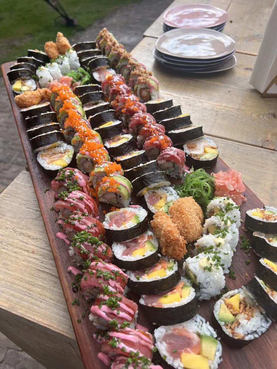 Houten sushiplank met rijen maki en nigiri
